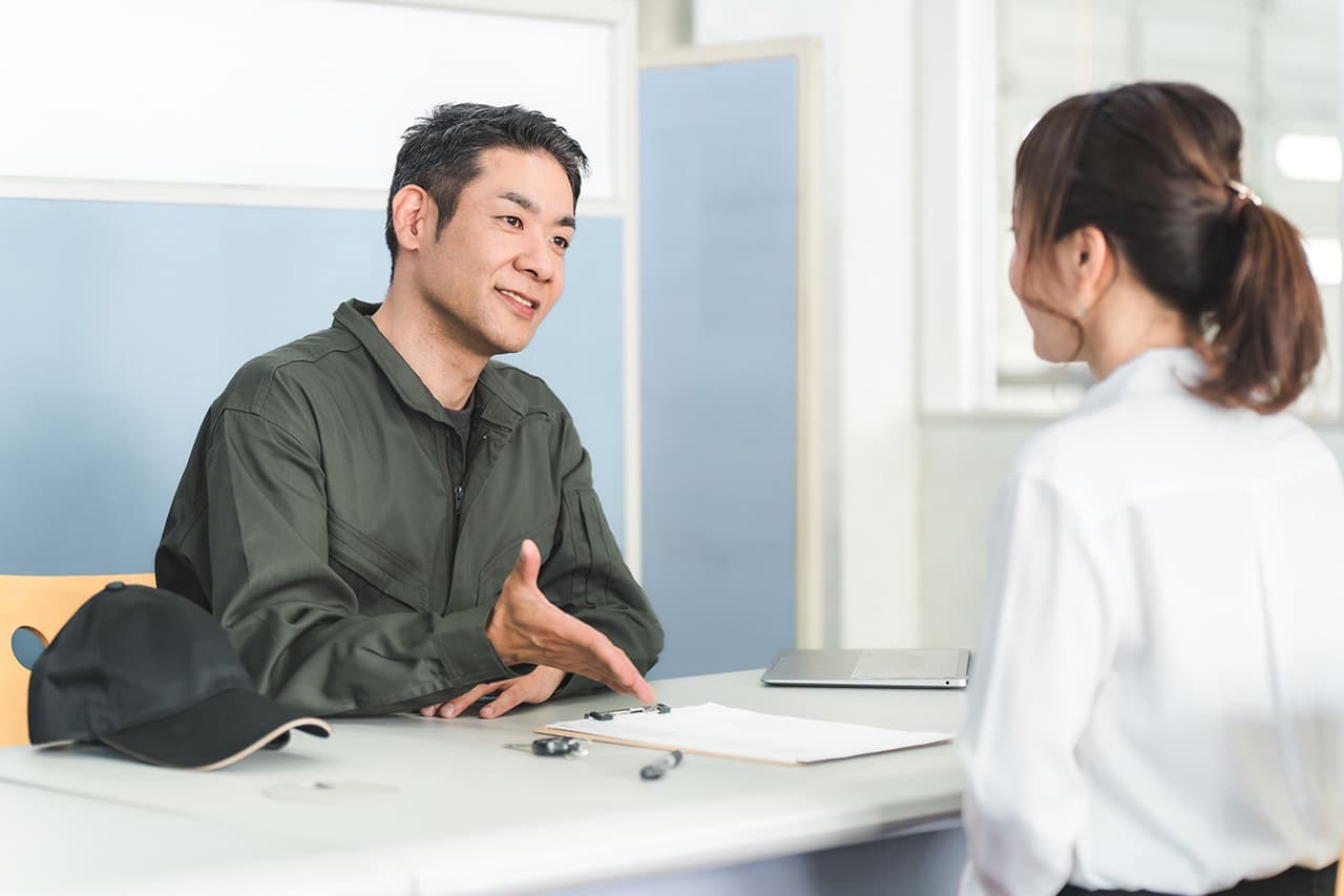 整備工場の受付で説明をしているスタッフ男性と女性