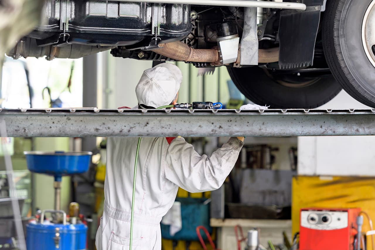 トラックのメンテナンス中の整備士